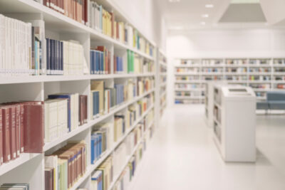 Books in modern library in Stuttgart, Germany. Library with many shelves, books, long perspective, soft focus. Library interior with shelves filled with books. Concept of education, research
